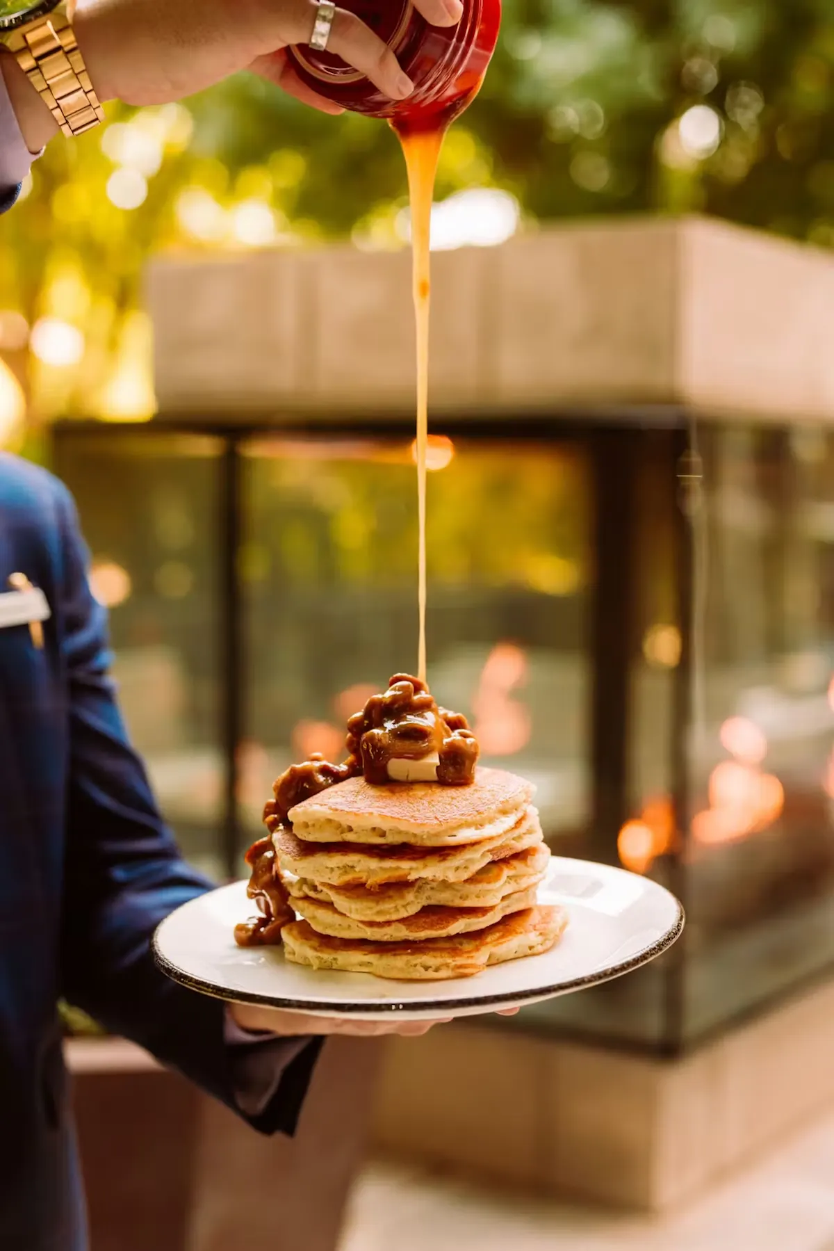 a person holding a plate of pancakes